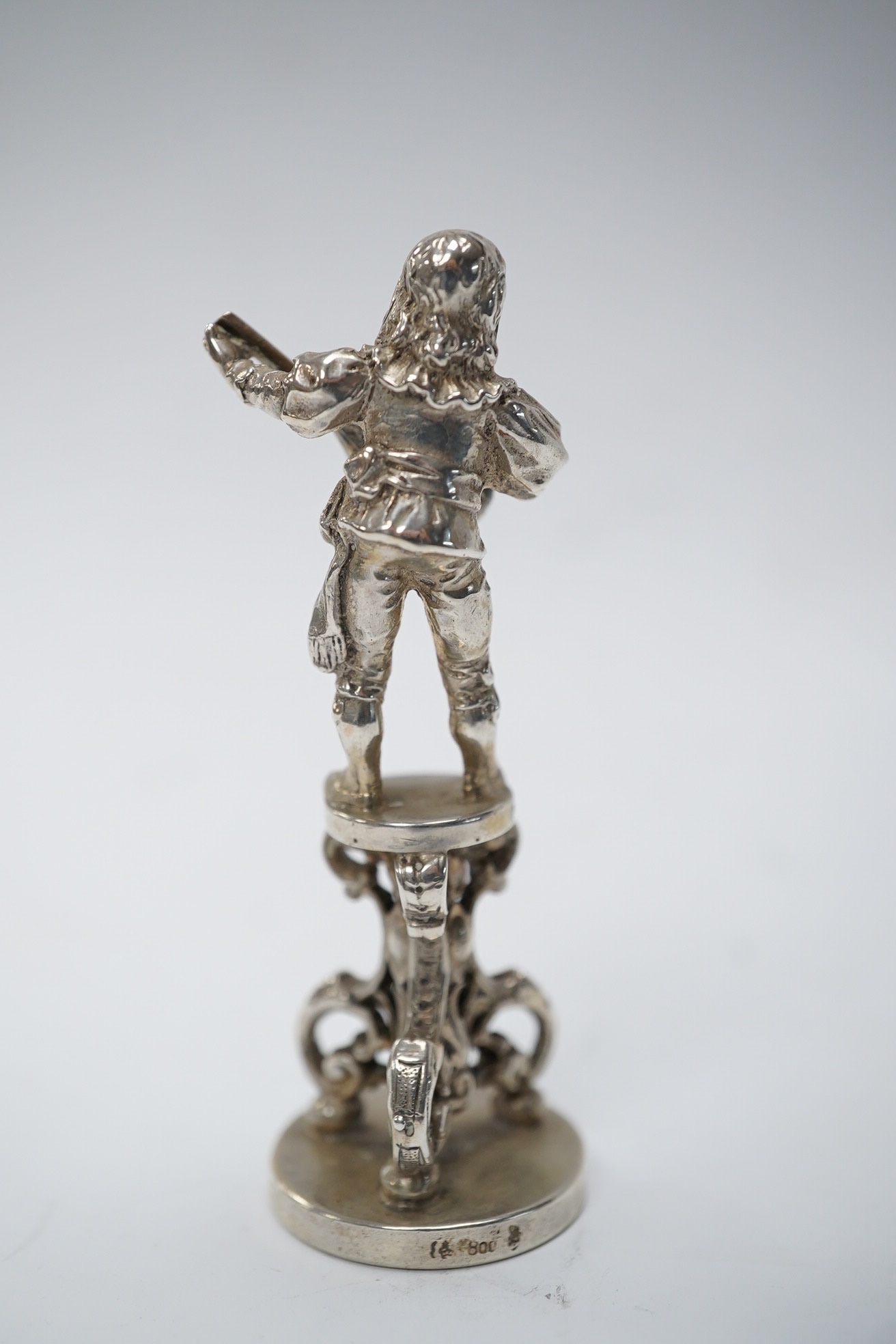 An early 20th century German 800 standard figural desk seal, modelled as a musician, 68mm. Condition - fair to good